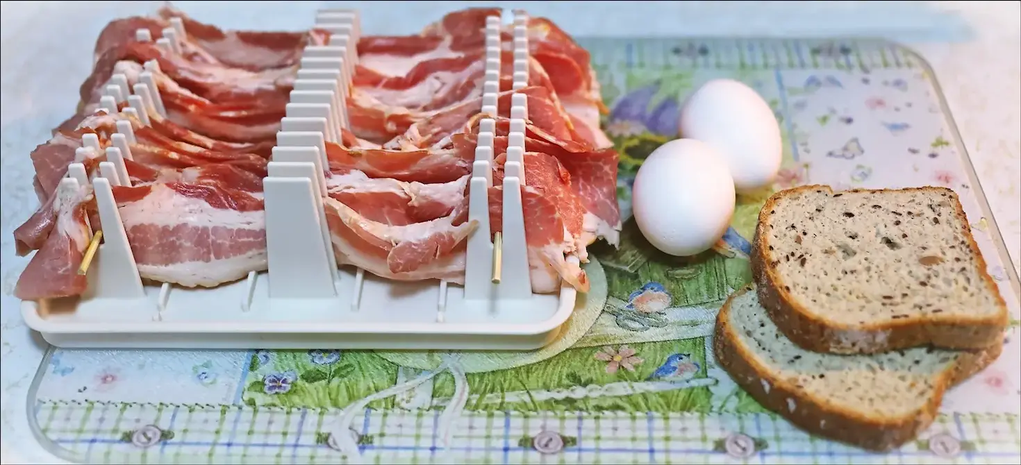 A wide shot of uncooked bacon, along with untoasted bread and uncracked eggs, merely the beginning of the BLT journey.